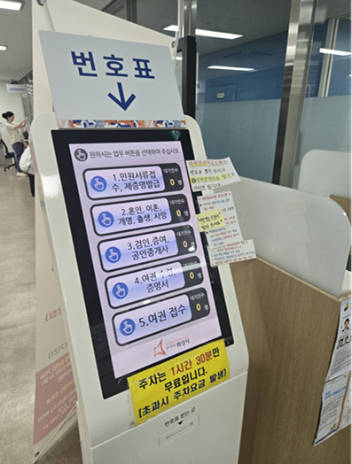 번호표와 여권접수를 위해 기다리는 사람들의 모습과 동탄출장소의 실내 모습